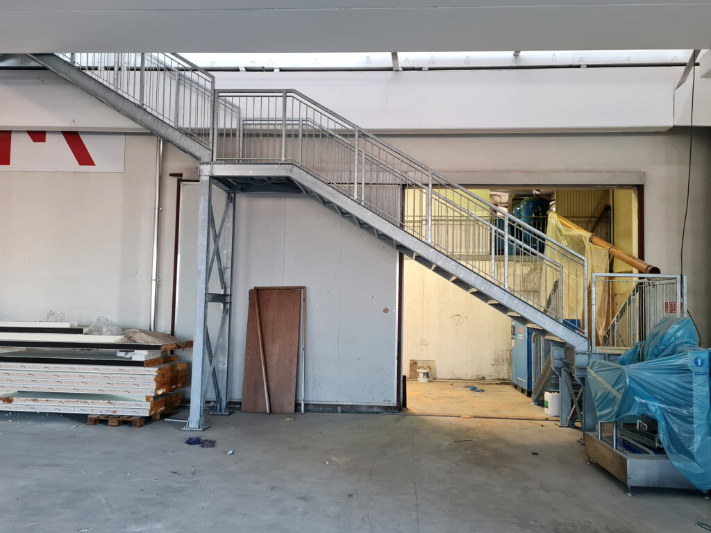 Installazione pannelli coibentati Agriform Parmareggio con scala metallica di accesso alle zone tecniche durante lavori di ampliamento.